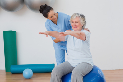 caregiver assisting senior woman for exercise routine